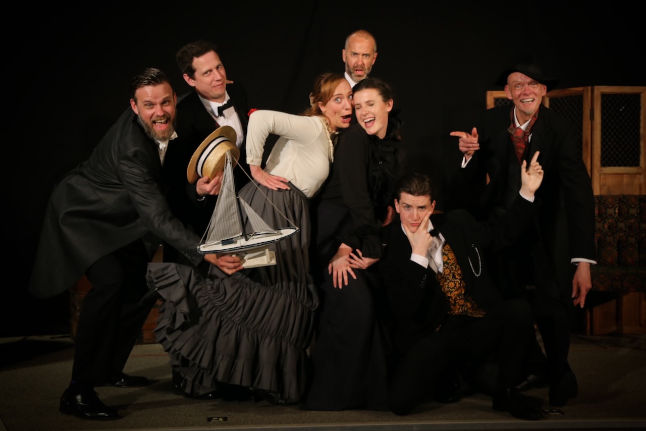 Actors pose for a fun group shot in period dress