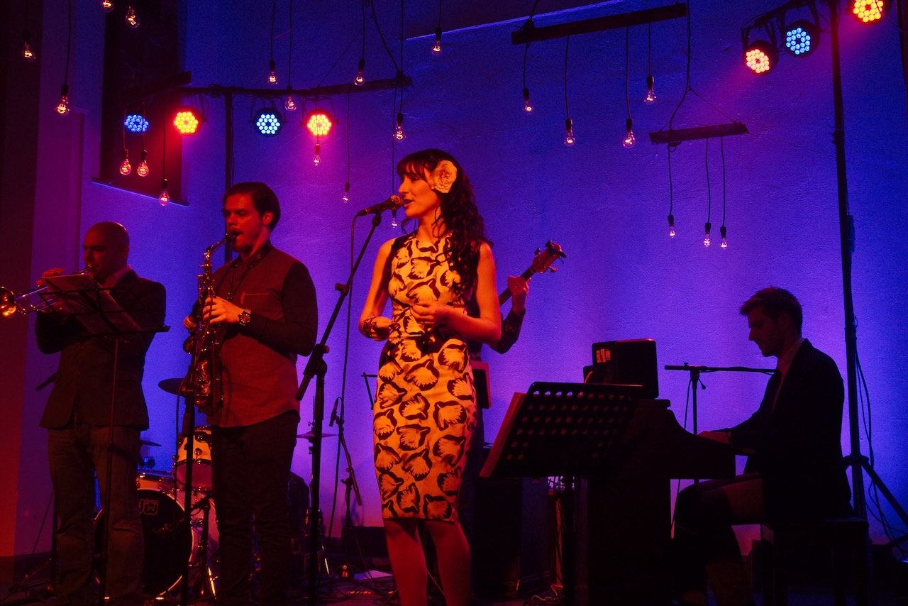 The Roots of Jazz musicians performing with purple stage lighting
