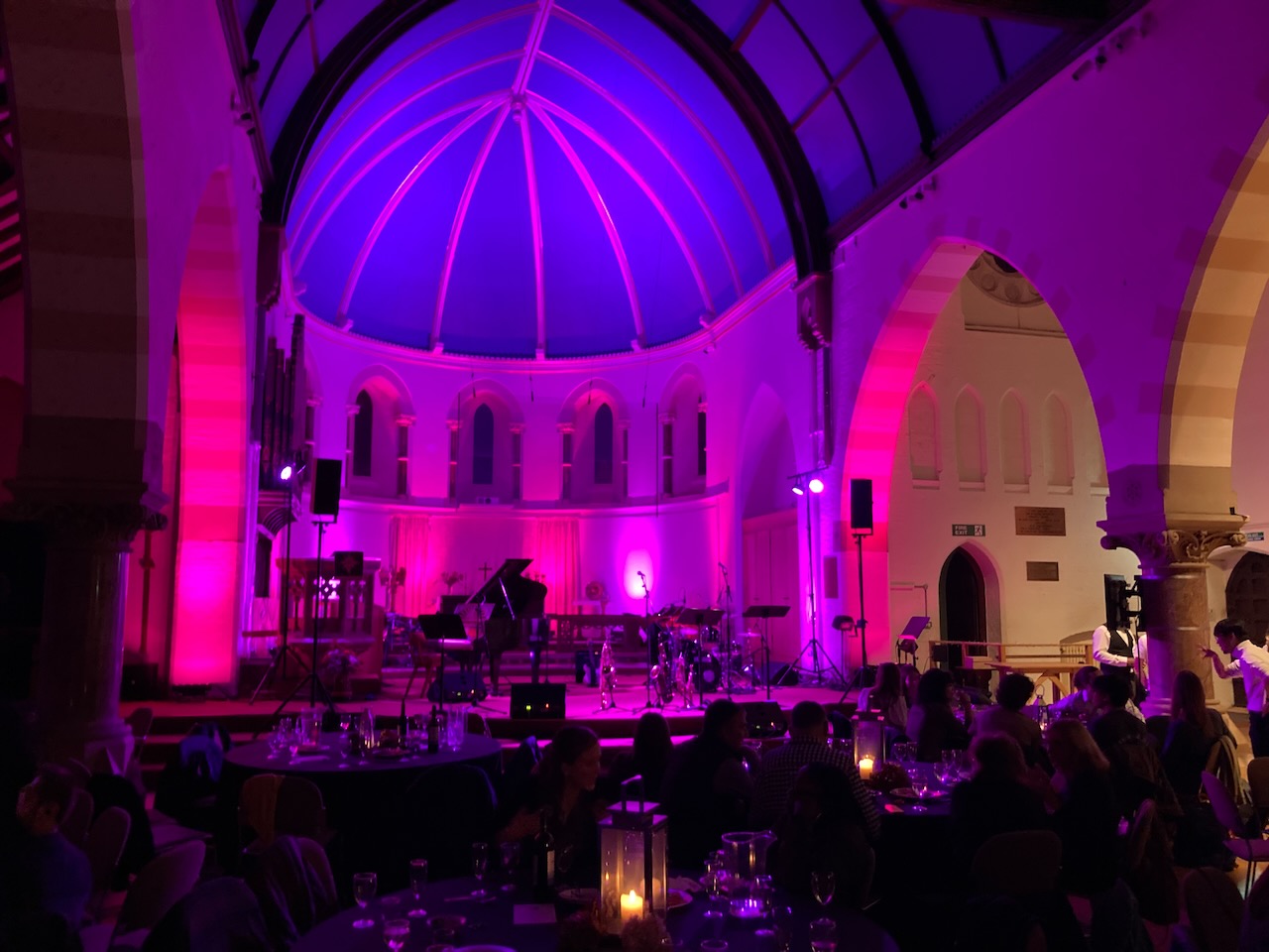 Round church interior transformed with purple lighting for The Roots of Jazz